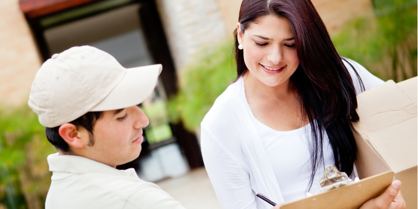 23 - Woman receiving a package at home from a delivery guy